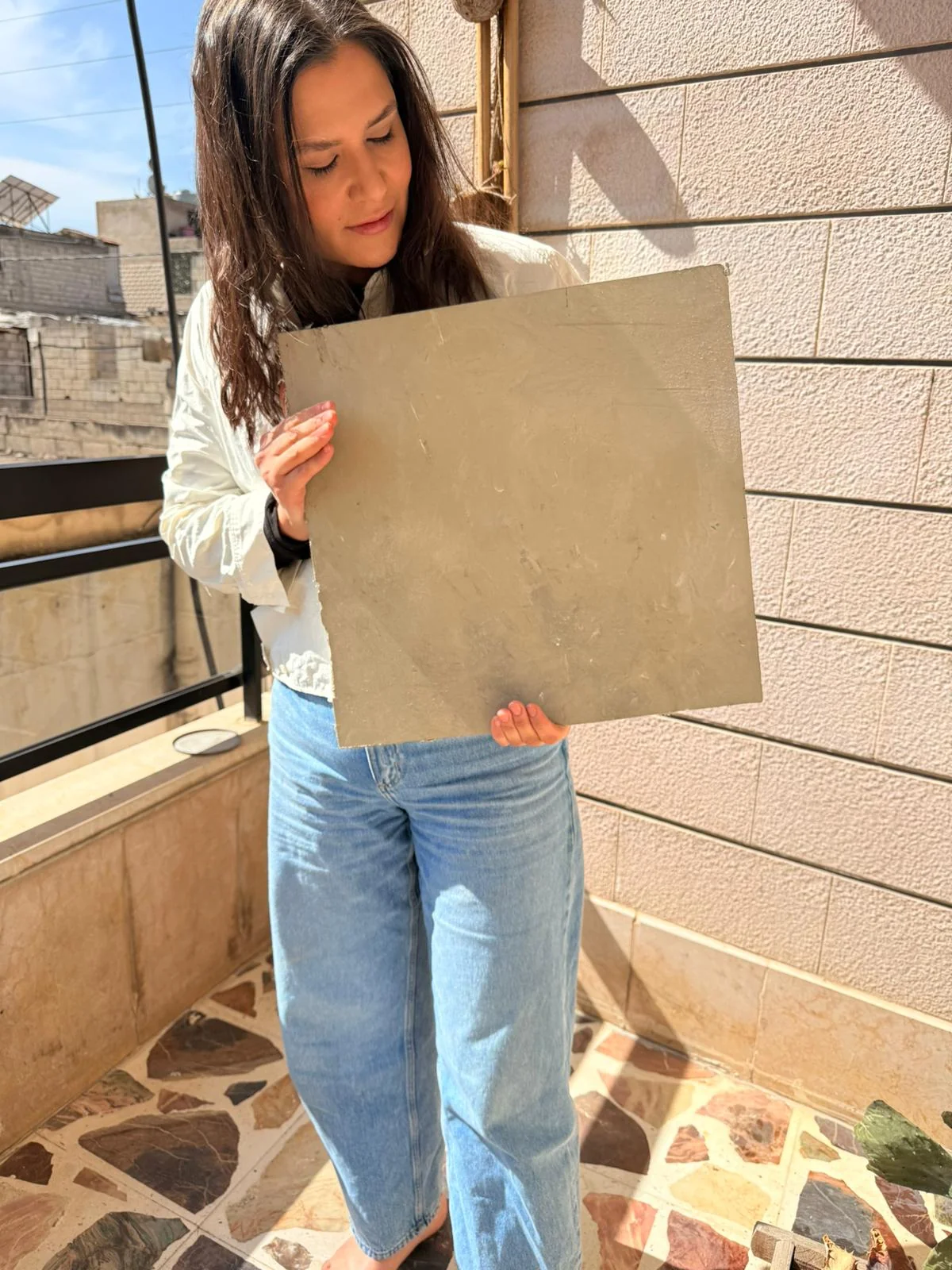 Diana Saleh holding a mineral panel in daylight